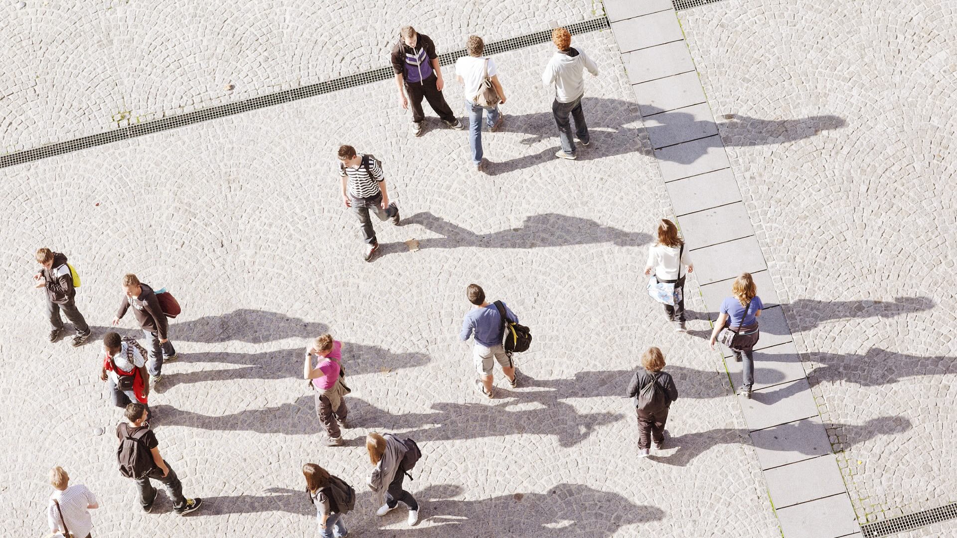 A crowd walking across a paved public space